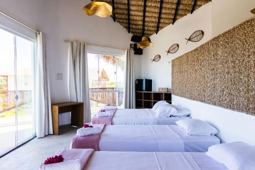 a bedroom with three beds and a large window at Casa de Sal Ocean - Cajueiro da Praia (Vista Mar) in Cajueiro