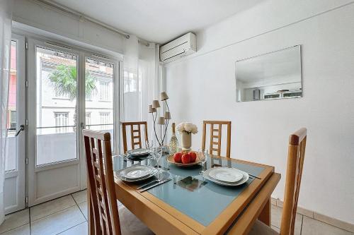 une salle à manger avec une table et des chaises en verre dans l'établissement LES MIMOSAS - Ideal Congress - Apartment for 4 people in Cannes, à Cannes