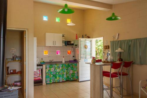 a kitchen with green lights on the wall and a counter at Complejo Utopia-Chacras de la Primavera, Tanti in Tanti