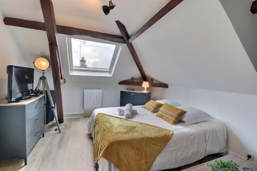 une chambre avec un lit, une télévision et une fenêtre dans l'établissement Le Printemps - Cozy et Calme - Mon Groom, à Troyes