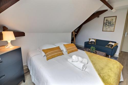 - une chambre avec un lit blanc et un canapé bleu dans l'établissement Le Printemps - Cozy et Calme - Mon Groom, à Troyes