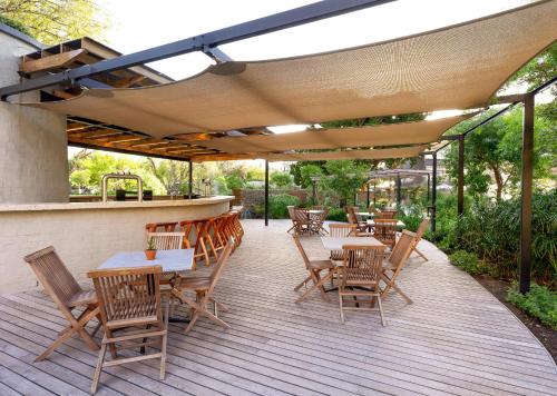 a patio with tables and chairs and a bar at Avalon Springs by Dream Resorts in Montagu