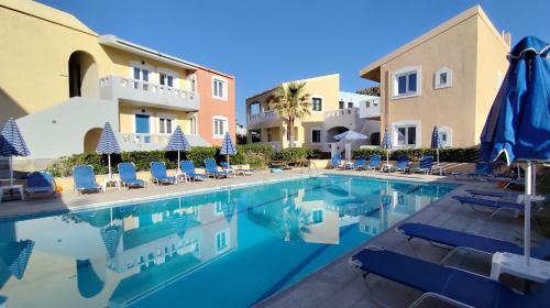 a pool at a hotel with chairs and umbrellas at Niros Beachfront Aparthotel in Kokkíni Khánion