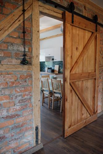 an open barn door in a brick wall at Apartament Zielono Mi, Pilchowice in Wleń