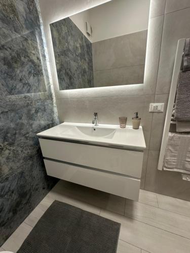 un bagno bianco con lavandino e specchio di Casa al mare a Finale Ligure