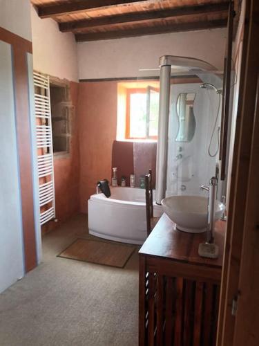 une salle de bain avec une baignoire et un lavabo dans l'établissement maison, à Montesquiou
