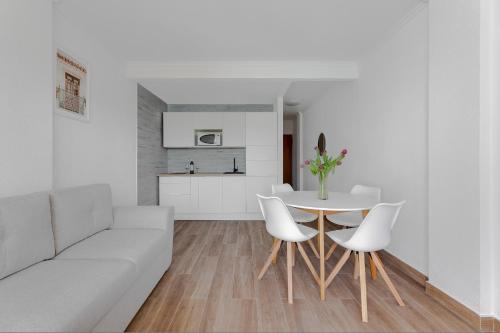 un salon avec un canapé blanc, une table et des chaises dans l'établissement Apartament Palmside Torrevieja, à Torrevieja