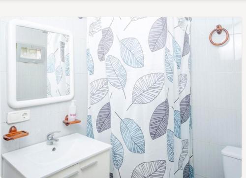baño con cortina de ducha con hojas en Casita rural de invitados, en Alcalá de Guadaira