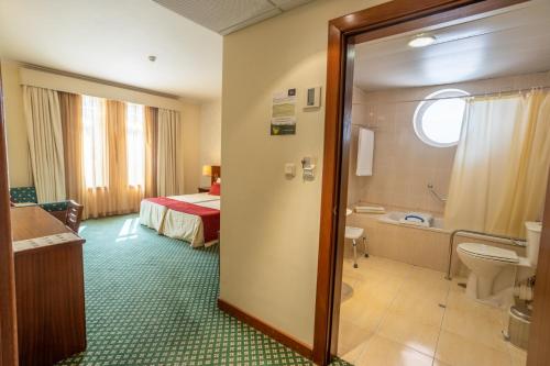 a hotel room with a bed and a bathroom at Hotel Eurosol Gouveia in Gouveia