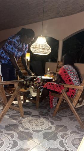 a man standing over a wooden table with a woman at Casa Contente Bake in Abene