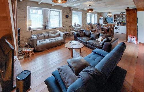 un salon avec des canapés en cuir et un salon avec un chien allongé dessus dans l'établissement 4 Bedroom Lovely Home In Riec-Sur-Belon, à Riec-sur-Bélon
