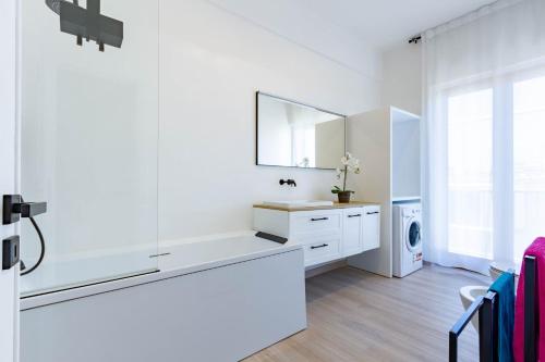 ein weißes Badezimmer mit Waschbecken und Spiegel in der Unterkunft Appartamento La Perla Luxury - MyHo Casa in Vieste