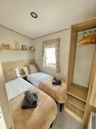 a bedroom with two beds and a window at Trecco Bay Caravan Cosy Coastal Retreat in Porthcawl