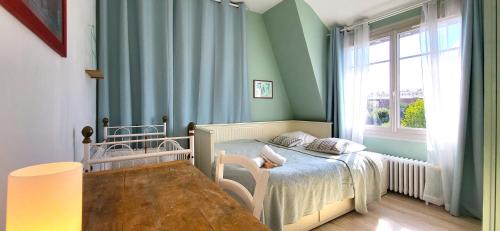 une petite chambre avec un lit et une fenêtre dans l'établissement Konforta : Paisible maison d'été avec grand jardin, à Sainte-Geneviève-des-Bois