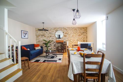 un salon avec une table et un canapé bleu dans l'établissement -TY GWEN- Maison de ville au centre de Concarneau, à Concarneau