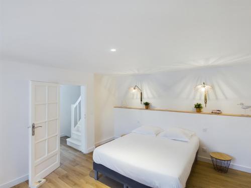 - une chambre blanche avec un lit et deux lumières sur le mur dans l'établissement -TY GWEN- Maison de ville au centre de Concarneau, à Concarneau