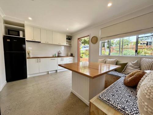 a kitchen and living room with a table and a couch at Little Banksia in Sawtell