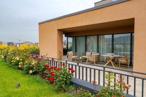 a balcony with a table and chairs and flowers at Qosmo Brasov Hotel in Braşov