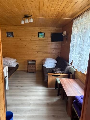 a room with two beds and a couch in a cabin at Domki u Dorotki in Jantar