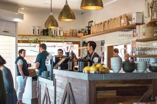 a group of people standing at a counter in a kitchen at Little Banksia in Sawtell