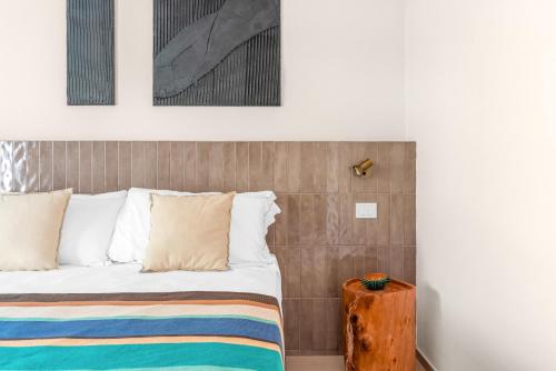 a bed with white pillows and a wooden table at Sabhé Gallipoli in Gallipoli