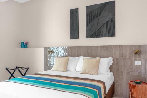 a bedroom with a bed with a colorful striped blanket at Sabhé Gallipoli in Gallipoli