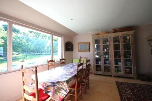 a dining room with a table and a large window at Maisons de vacances 4* à Belle ile en Mer, 5 chambres, 2 salles de bains, avec jardins privatifs in Bangor