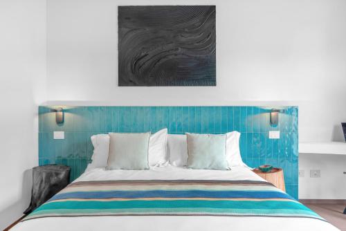 a bedroom with a bed with a blue wall at Sabhé Gallipoli in Gallipoli