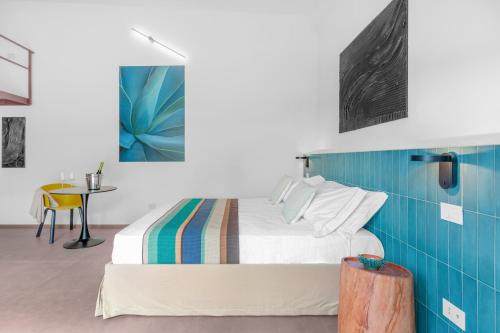 a bedroom with a bed with a blue wall at Sabhé Gallipoli in Gallipoli