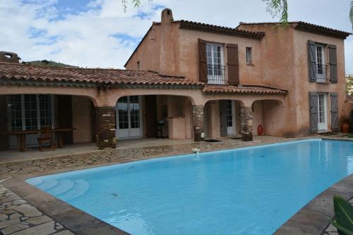 une maison avec une piscine devant une maison dans l'établissement Faïza, à La Garonnette-Plage