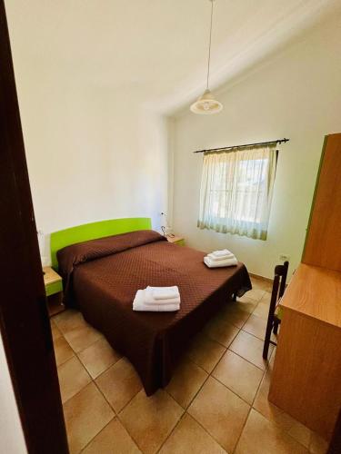 a bedroom with a bed with two towels on it at Agriturismo Monte Istulargiu in Valledoria