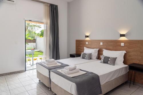 a bedroom with a large bed and a large window at Celestial Studios in Kavos