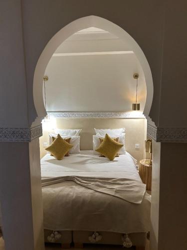 a bedroom with a large white bed with pillows at Riad N'S & Spa in Marrakech
