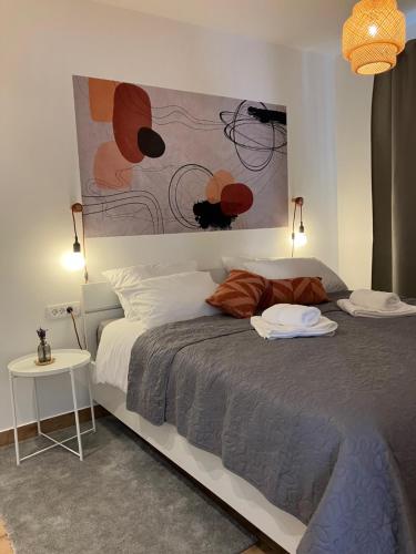 a bedroom with a bed with a painting on the wall at Apartment Oblica-beautiful new, well equipped apartment in Kastav