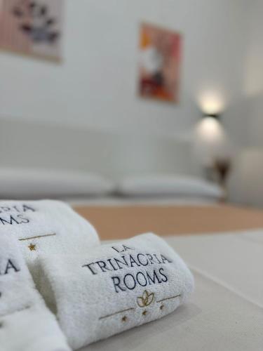 a towel with the translation rooms written on it on a bed at La Trinacria Rooms in Trapani