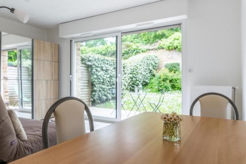 une salle à manger avec une table en bois et une fenêtre dans l'établissement Studio Chateau Limoges Vannes, à Vannes