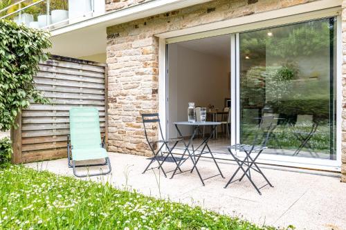 un patio avec des chaises et une table devant un bâtiment dans l'établissement Studio Chateau Limoges Vannes, à Vannes