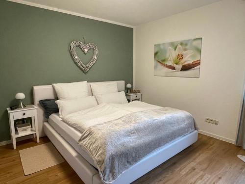 una camera da letto con un letto con un cuore sul muro di Ferienwohnung Osterquelle a Freisen