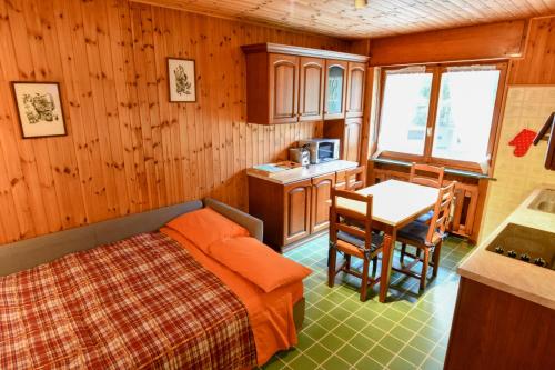 a bedroom with a bed and a table and chairs at Casa Herin-La borna du Tésòn - CIR VDA - VALTOURNENCHE - n 0254 in Valtournenche