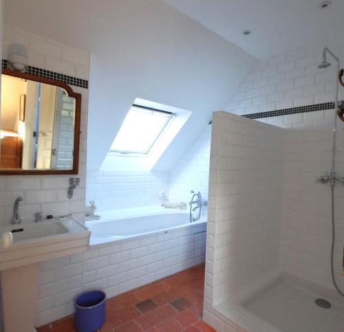 a bathroom with a tub and a sink and a window at Maisons de vacances 4* à Belle ile en Mer, 5 chambres, 2 salles de bains, avec jardins privatifs in Bangor