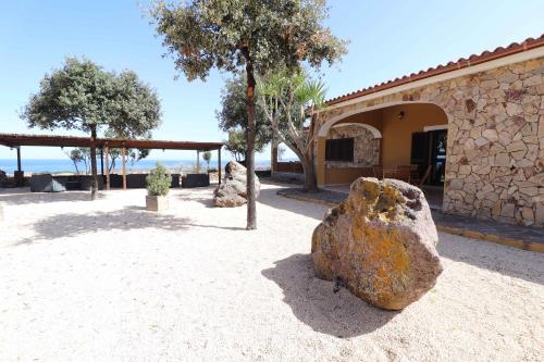 a large rock sitting in front of a building at Agriturismo Monte Istulargiu in Valledoria