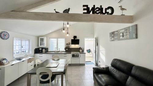 une cuisine et un salon avec un canapé et une table dans l'établissement Les Alouettes, maison avec studio pour 4 personnes proche de la baie., au Crotoy