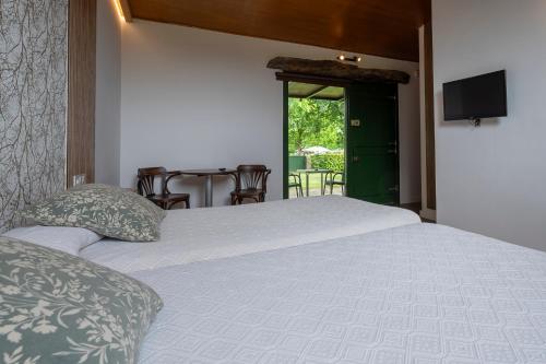 a bedroom with a bed and a table with chairs at Alojamientos rurales O Acivro in A Rúa
