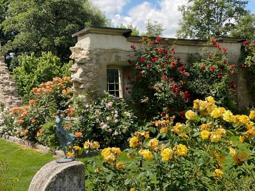 a garden with flowers and a building with a bird statue at Design Ferienwohnung mit Bauerngarten in Waldkirchen