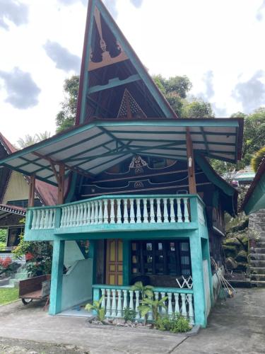 a blue building with a porch and a balcony at Marroan Acc in Tuk Tuk