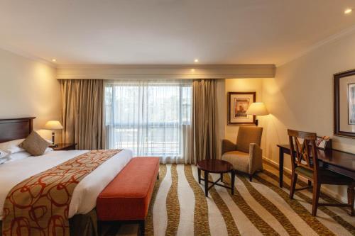 a hotel room with a bed and a desk at Kigali Serena Hotel in Kigali