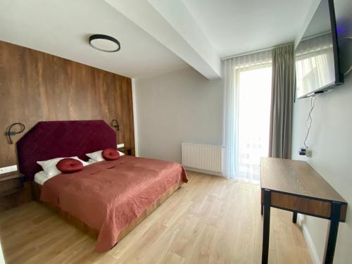 a bedroom with a bed with red sheets and a window at Apartament Środowa 6 by Prestige Home in Szczecin