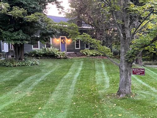 a house with a yard with a sign in the grass at Red Fox Run B&B in Cazenovia