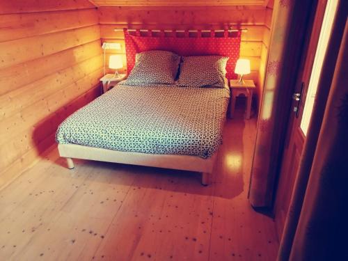a bedroom with a bed in a wooden room at CHALET 5p tout confort bias mimizan dans village vacances in Bias