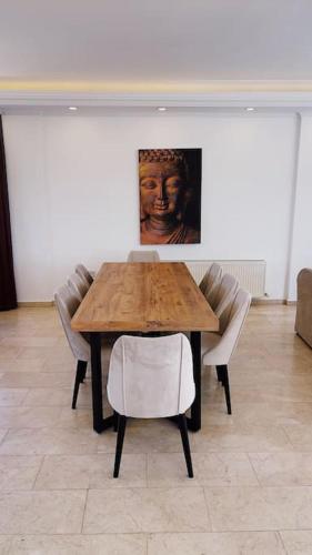 a wooden table with chairs and a painting on the wall at Tropical Mountain Villa With Pool & Sea View in Kérynia
